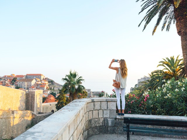 Tourist taking photo of cityscape with cellphone