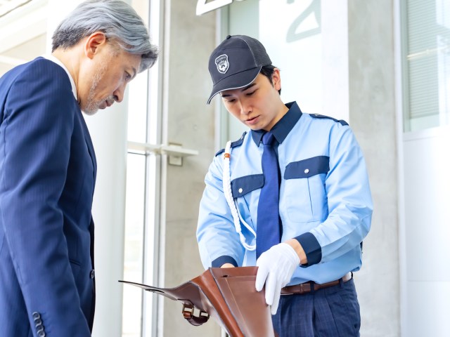 Airport security agent inspecting passenger's briefcase