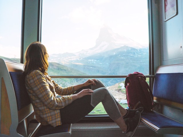 Traveler looking at mountain outside train window