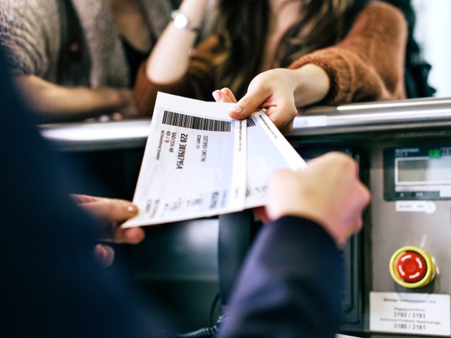 Airline passenger handing gate agent boarding passes