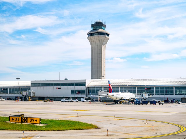 View of aircraft parked at terminal and air traffic control tower at Detroit Metropolitan Wayne County Airport in Michigan