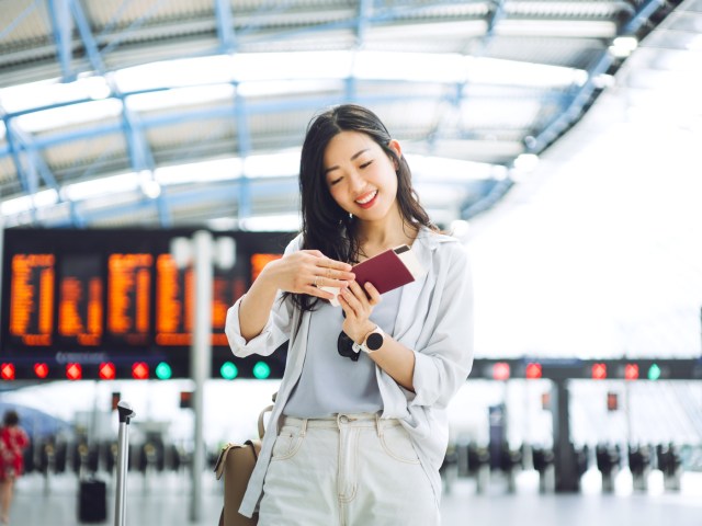 Airline passenger checking boarding pass in terminal