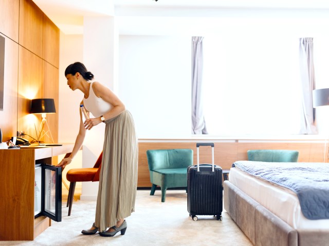 Hotel guest opening mini fridge in room