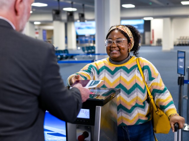 Airline passenger scanning boarding pass at gate