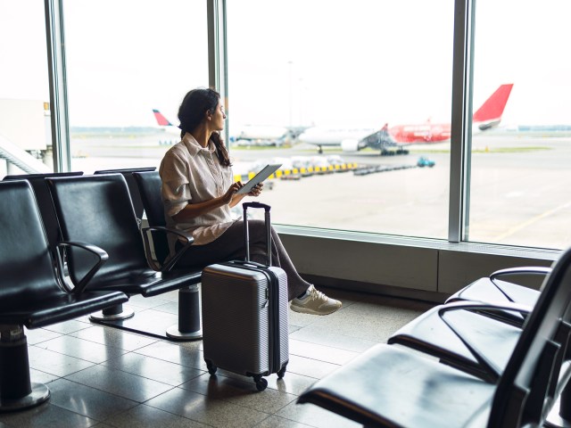 Airline passenger sitting at airport gate looking out of window