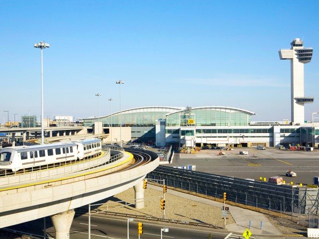 AirTrain passing by passenger terminal and air traffic control tower at New York's John F. Kennedy International Airport