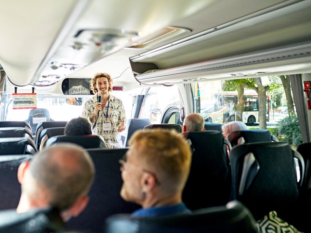 Guide speaking to tour group on bus