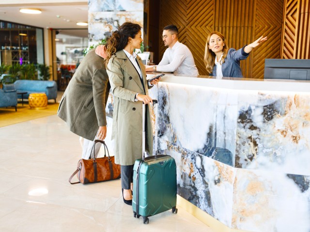 Hotel guest with luggage at front desk