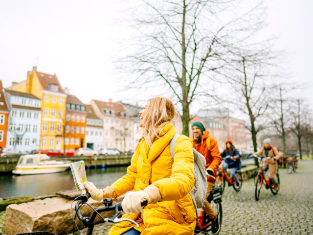 Tour group riding bikes along city canal