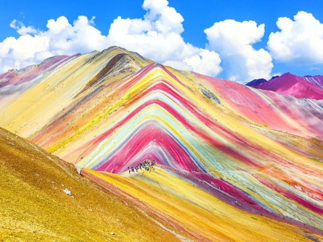 Hikers admiring rainbow colors of Peru's Vinicunca Mountain