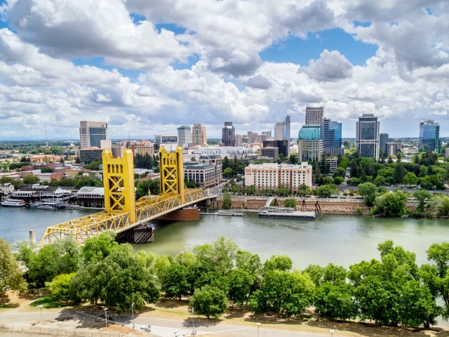 Aerial view of yellow bridge over the Sacramento River with downtown high-rises