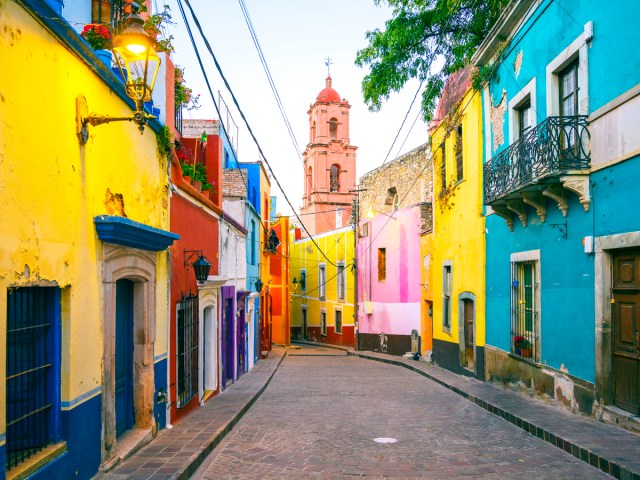 Narrow street lined with brightly painted buildings in Guanajuato, Mexico