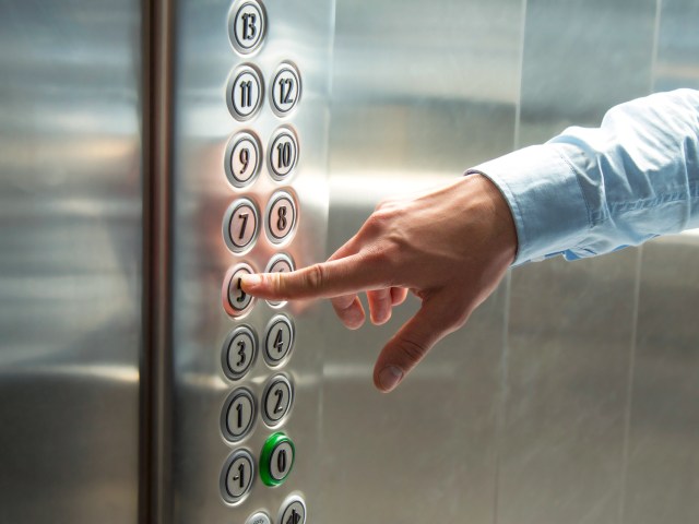 Close-up image of guest selecting floor on hotel elevator