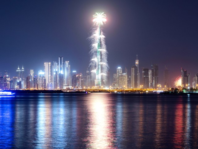 Light show on the Burj Khalifa against the Dubai skyline, seen across bay