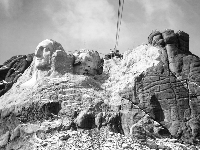 Historical black-and-white image of Mount Rushmore under construction in the 1930s