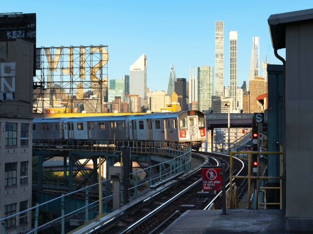 New York City subway on elevated track with skyscrapers in background