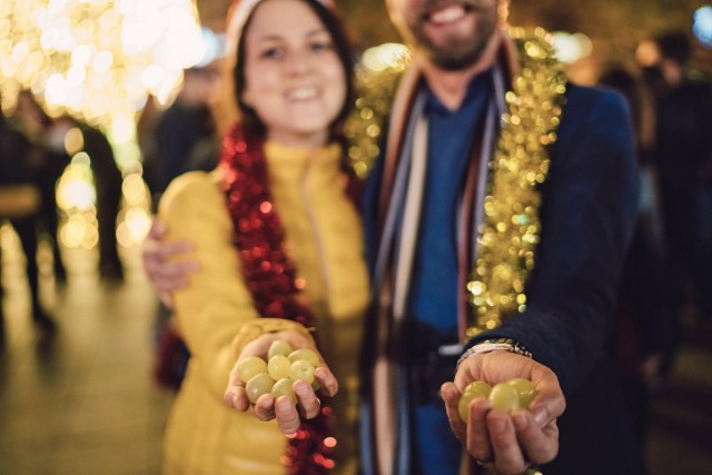 Revelers in Spain holding 12 grapes each for the new year