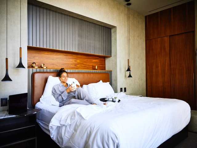 Guest lounging in hotel room bed