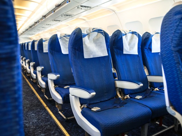 Rows of empty seats in economy class cabin on airplane