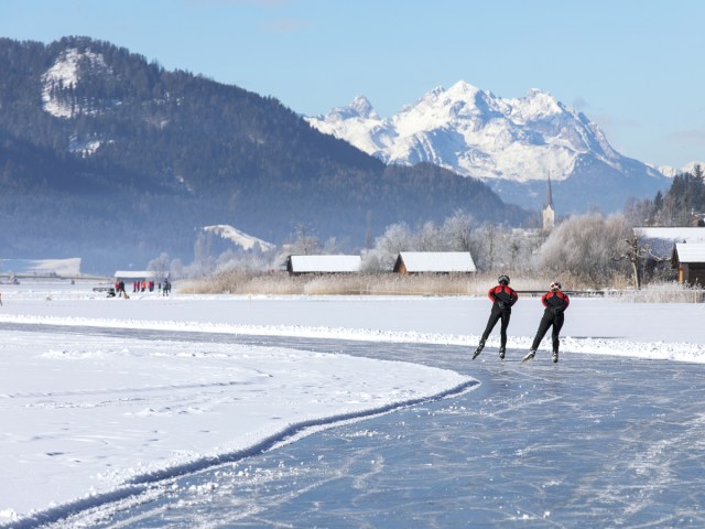 Skaters on frozen Lake Weissensee in Austria