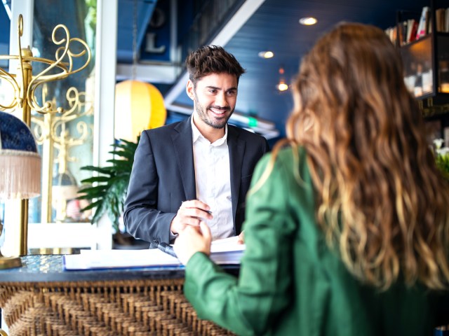 Hotel guest speaking to front desk employee