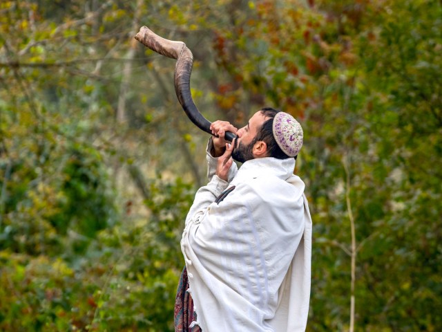 Jewish pilgrim blowing a shofar for Rosh Hashanah