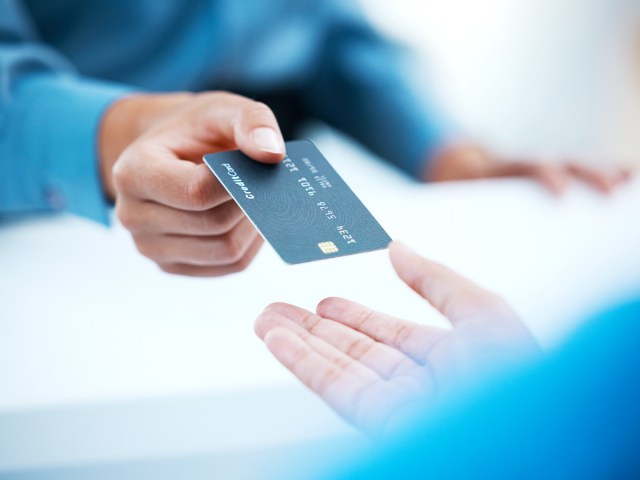 Close-up image of customer handing credit card to associate