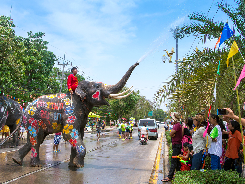 Elephant splashing water on revelers during Songkran Festival in Thailand