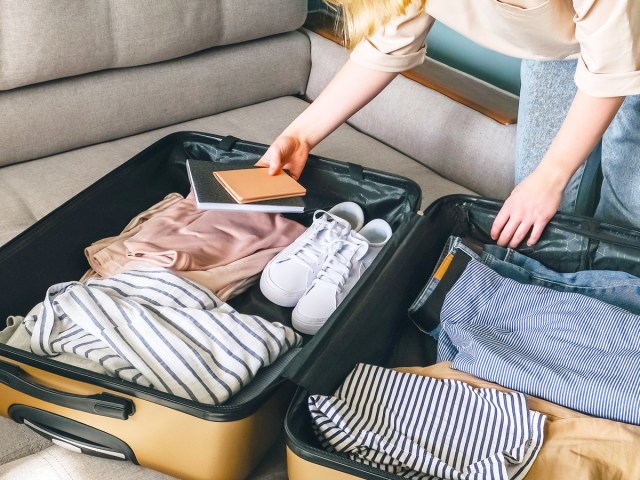 Traveler packing items in suitcase