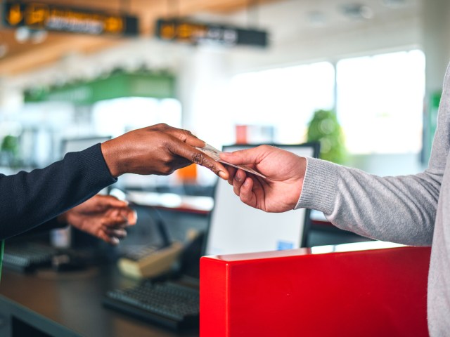 Airport agent handing passenger boarding pass