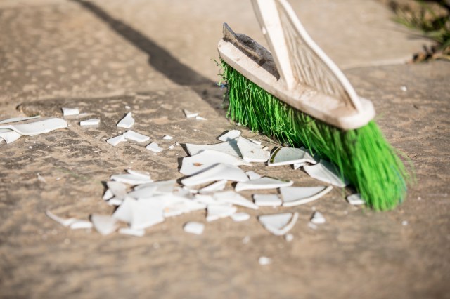 Close-up view of broom cleaning broken plates for Danish new year celebration