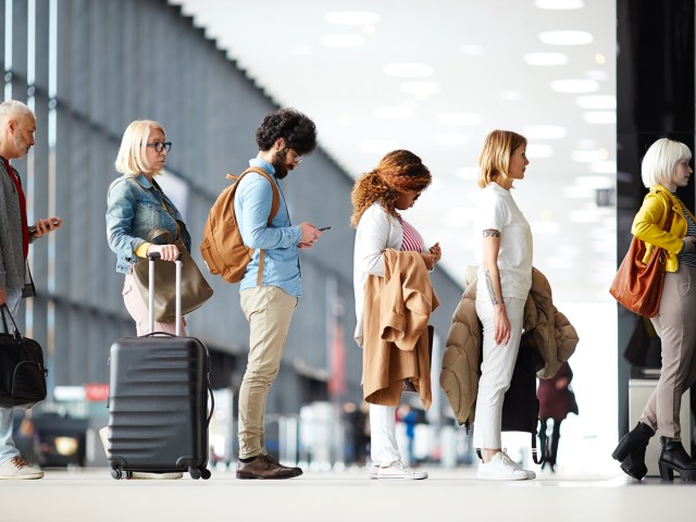 Air travelers waiting in line at airport