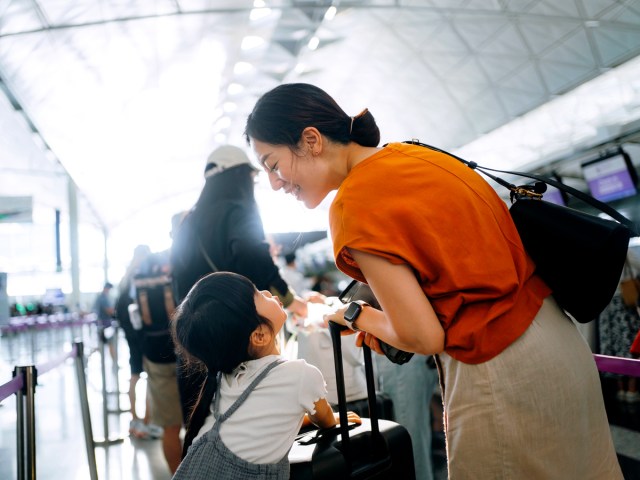 Mother and child standing in airport check-in queue