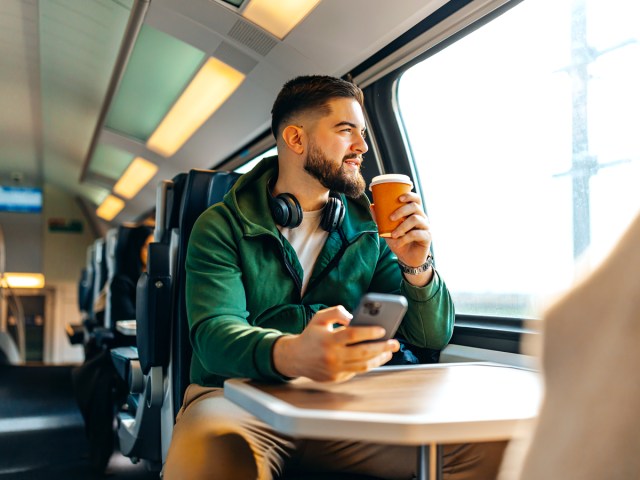 Amtrak passenger sipping coffee and looking out window