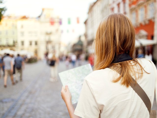 Tourist studying map in city square