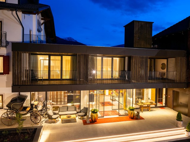 Guest rooms lit at night at Hotel Alte Goste in Valdaora, Italy