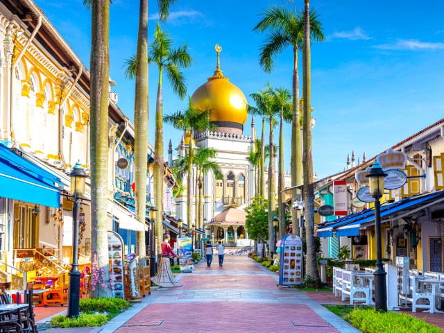 Shops lining street with view of gold-domed Sultan Mosque in Singapore