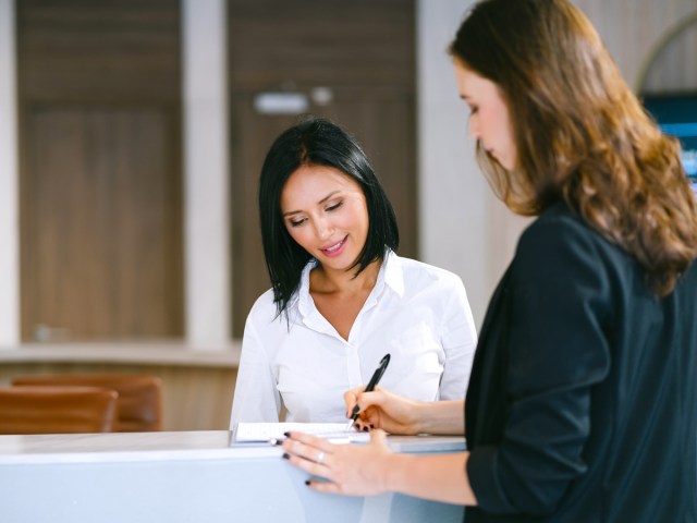 Traveler signing agreement at desk