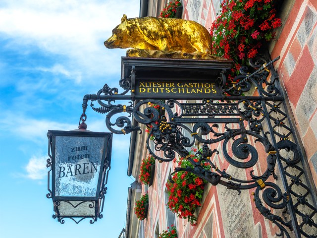 Golden bear statue atop sign for Zum Roten Bären hotel in Freiburg, Germany