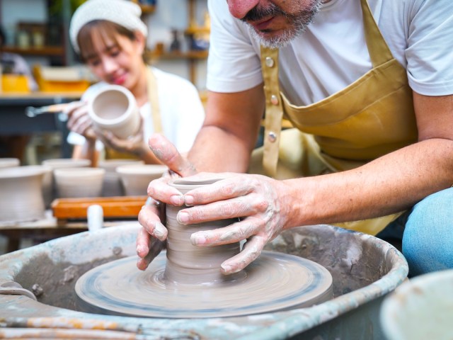 Person spinning clay to make pottery