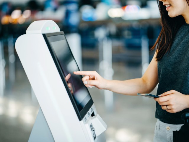 Traveler using electronic kiosk at airport