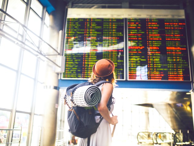 Air traveler looking up at airport departures and arrivals board