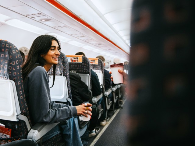 Passenger speaking to someone across aircraft aisle