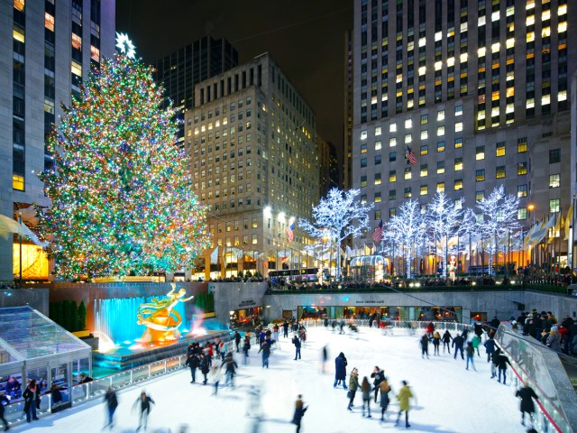 Ice skating at Rockefeller Center with decorated Christmas tree in New York City