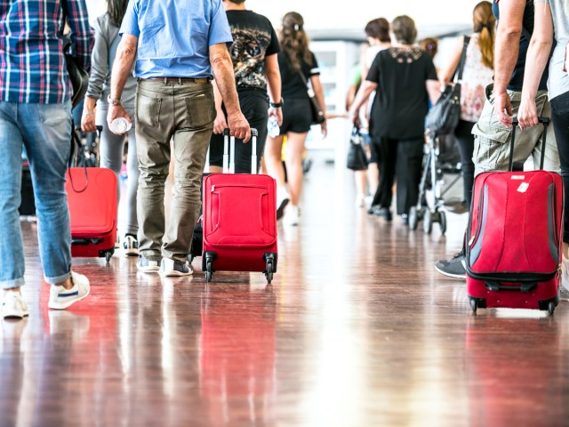 Passengers wheeling bags through airport