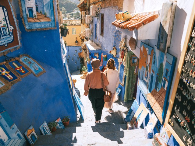 Couple walking down steps through market in Chefchaouen, Morocco 