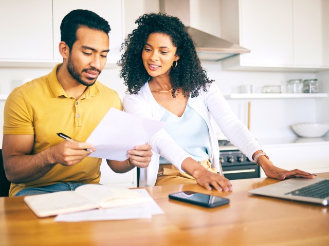 Two people reviewing papers in kitchen