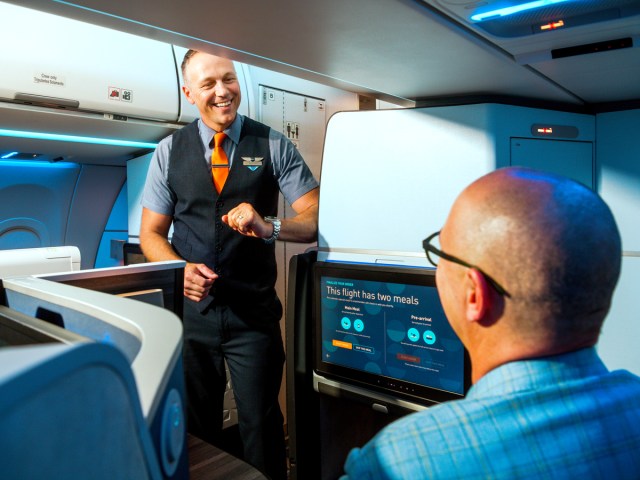 JetBlue Airways flight attendant interacting with Mint cabin passenger