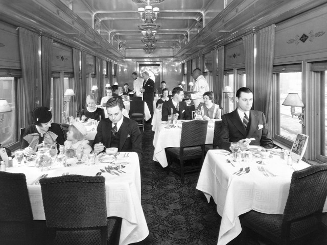 Historical image of passengers dining in elegant train car