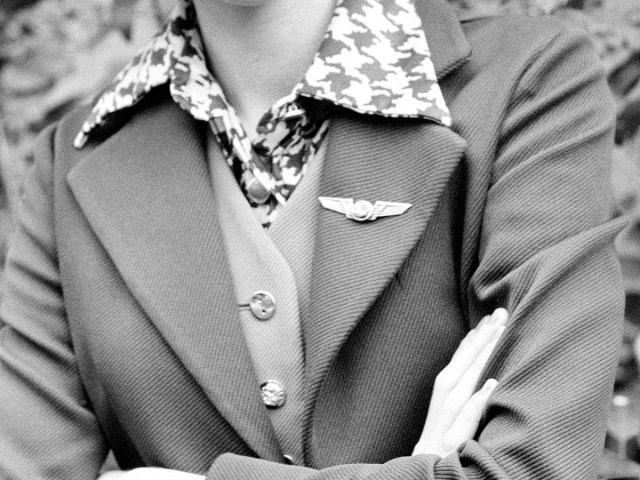 Historical image of flight attendant wearing wing pins on uniform